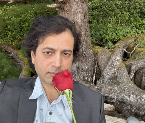 Photo shows the poet holding a rose.